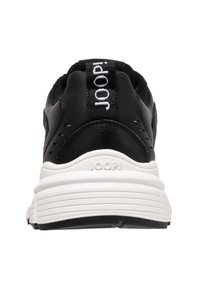 Baskets noires avec upper en cuir, semelle intermédiaire blanche, bout arrondi et accents texturés. Présente une étiquette de logo sur le talon.