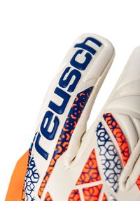 Close-up of white goalkeeper glove with blue "Reusch" logo and orange and blue geometric patterns on fingers and backhand.