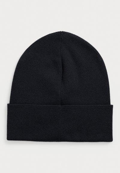 Črna pletena kapa s preklopom, enostaven dizajn, prikazana na nevtralni svetlo sivi ozadju.