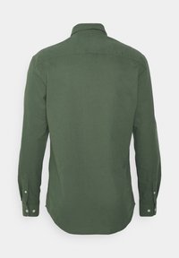 Langemouwen shirt van donkergroene katoen. Voorzien van een kraag, knoopmanchetten en een rechte pasvorm met een gebogen onderkant. Soepele textuur.