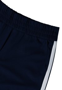Pantaloni atletici blu navy con cintura elastica e striscia laterale bianca, che mostrano la sezione superiore e la tasca destra.
