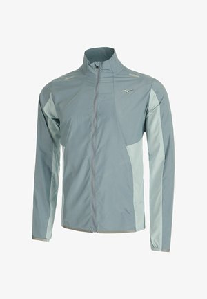 Coupe-vent léger, zippé, de couleur bleu clair avec des panneaux latéraux en bleu plus doux contrastants et des accents réfléchissants sur les épaules.