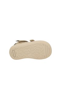 Beige Sneaker mit einer strukturierten Gummisohle, die ein verspieltes Muster aufweist. Zwei Klettverschlüsse im oberen Bereich verbessern die Anpassungsfähigkeit und den Komfort.