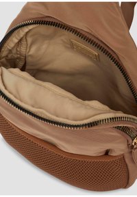 Borsa in tessuto marrone con apertura a zip, dotata di una fodera interna liscia e di una sezione inferiore in rete testurizzata. Dettaglio della zip in tono oro.