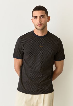 Zwart T-shirt met korte mouwen en patroon, een ronde halslijn, met een subtiel goudkleurig logo op de borst en contrasterende manchetten.