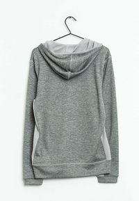 Grå hoodie med en strukturerad yta, som har en ljusgrå huva och sidodetaljer. Inkluderar en upphängningsslinga och ribbade muddar.