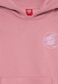 Lichtroze hoodie van zacht materiaal, met een wit en roze "SANTA CRUZ" logo op de linkerborst en een voorzak.