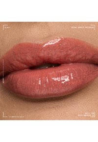 Lèvres brillantes couleur corail rosé avec une texture naturelle, légèrement entrouvertes, mettant en valeur un gloss à lèvres scintillant et lisse sur une peau douce.