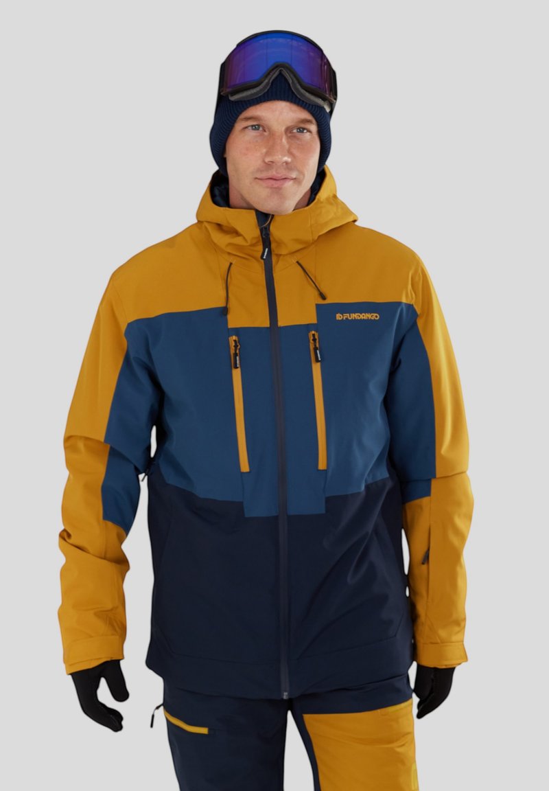 Veste de ski jaune et bleu marine avec capuche, deux poches poitrine zippées et poignets réglables, fabriquée à partir d'un matériau résistant à l'eau.
