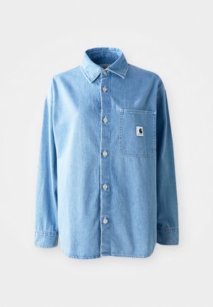 Camisa de denim azul claro con cuello, mangas largas y botones plateados. Presenta un único bolsillo frontal con una etiqueta de logo.