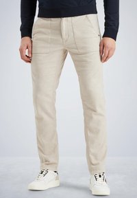 Beige katoenen broek met een rechte pasvorm, voorzien van voorzakken en een klassiek taillebandontwerp. G gedragen met witte sneakers.