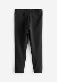 Zwarte leggings met een gladde textuur, een elastische tailleband met het woord "NEXT" en een strakke pasvorm die tot de enkels reikt.