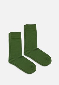 Dunkelgrüne Baumwollsocken mit gerippten Bündchen, glatter Textur, mid-calf Länge und ohne sichtbare Muster oder Hardware-Details.