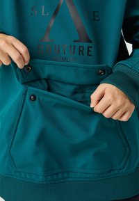 Felpa verde acqua con una grande tasca frontale con bottoni a scatto, polsini a costine e stampa del logo nero audace sopra la tasca. Texture liscia.