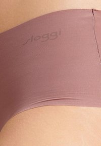Saumaton, ribbed kangas pölynpunaisena. Sisältää pehmeän vyötärönauhan ja hienovaraisen brändäyksen. Sujuva tuntuma ihoa vasten.