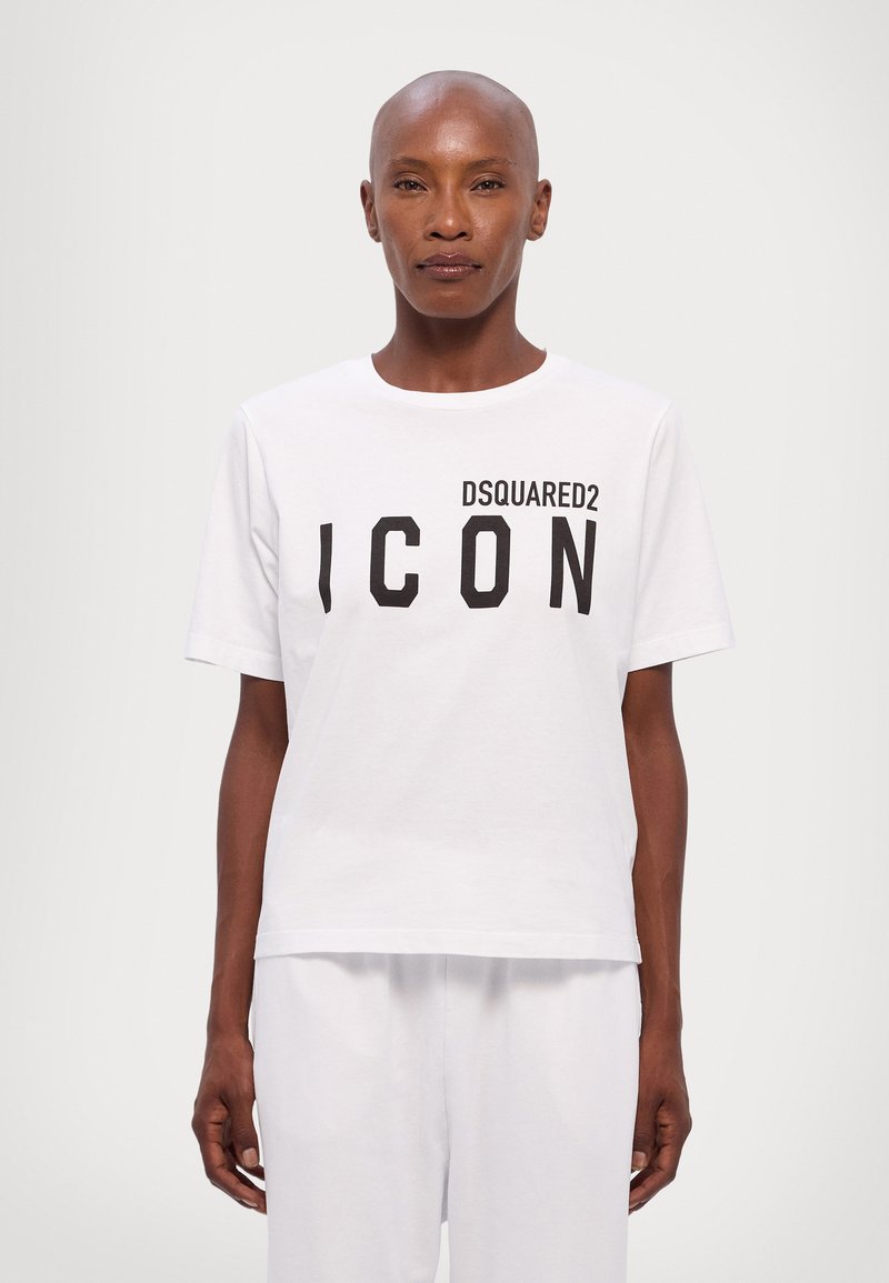 Valkoinen puuvillapaita, jossa on rohkea musta "DSQUARED2 ICON" -teksti. Lyhyet hihat, pyöreä kaula-aukko, rento leikkaus, sileä rakenne.
