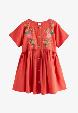 Lühikeste varrukatega punane kleit, millel on ees nööbid ja roosa-rohelise lillemustriga tikand rinnal ning kogutud vöökoht, mis annab lehviva seeliku.