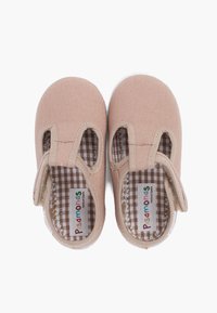 Chaussures en toile rose clair avec des découpes sur les côtés, semelles en caoutchouc blanches et doublure à carreaux bruns. Sangle Velcro pour un maintien sécurisé.