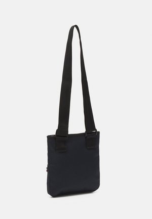 Navy blue fabric bag with a slim rectangular shape, two black adjustable straps, and a zippered closure at the top. Simple and modern design.