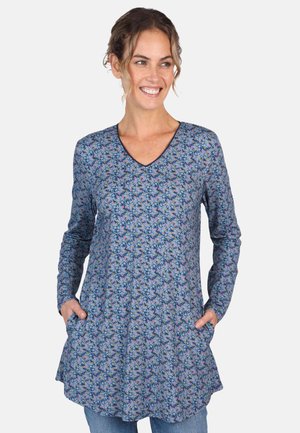 Long-sleeve tunic in blue fabric with floral pattern, V-neckline, and side pockets. Soft texture with a relaxed fit, flaring at the hem.