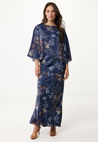 Navy bloemen tweedelige set in satijn, bestaande uit een vloeiende cropped top met brede mouwen en een aansluitende rok met een lange silhouet.
