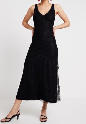Schwarzes Spitzenkleid mit tailliertem Oberteil, V-Ausschnitt und fließendem Rock. Subtile strukturierte Muster und schwarze Besatzdetails. Länge bis zur Mitte der Wade.
