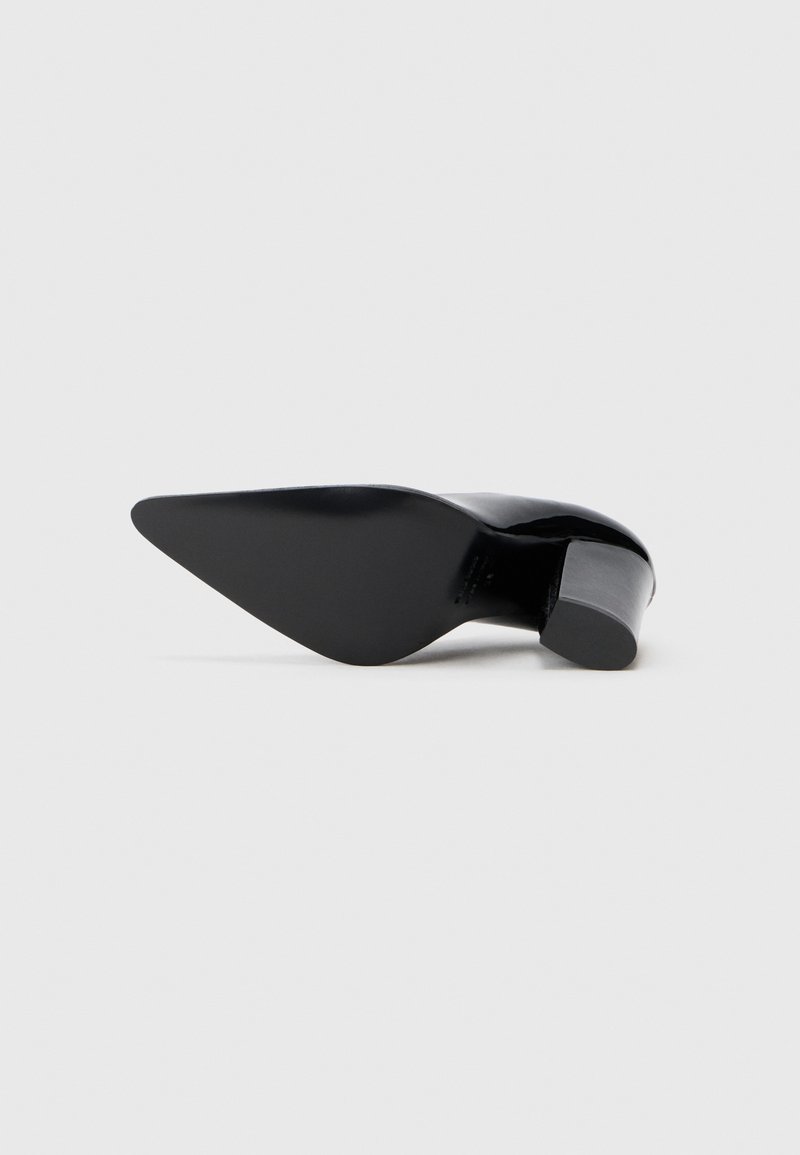 Sort højhælet sko med spids tå, slank overdel og kraftig hæl. Glat tekstur med en blank finish. Minimalistisk design.