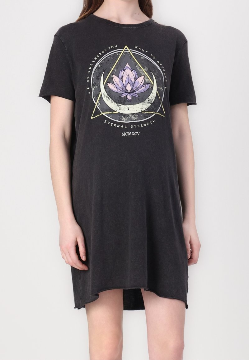 Robe t-shirt noire à manches courtes avec un design graphique mettant en avant une fleur de lotus et des formes géométriques, fabriquée en tissu doux et texturé.
