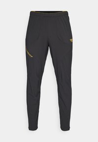 Schwarze Sporthose aus strukturiertem Stoff mit einer figurbetonten Passform, elastischem Bund und gelben Akzenten am linken Bein und in der Taille.