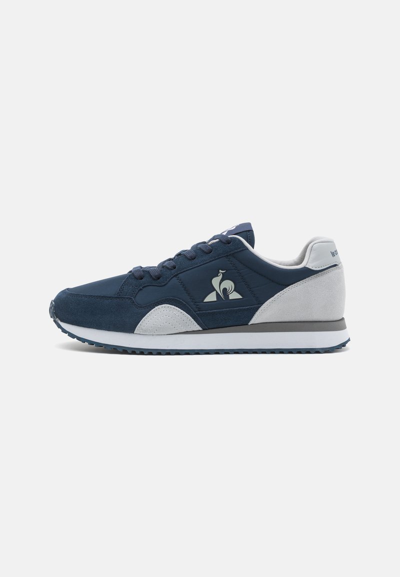 Chaussures de sport navy et grises en matériaux en daim et synthétiques, avec un bout arrondi, un laçage à l'avant et un accent logo sur le côté.