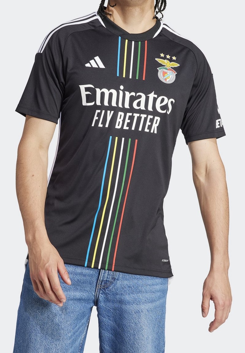 Czarna koszulka sportowa z krótkimi rękawami, z białymi i kolorowymi pionowymi paskami. Widnieje logo klubu oraz napis "Emirates Fly Better".