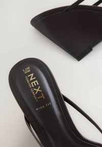 Mustad musta laia jalaga naiste sandaal õhukeste rihmadega, suurus 6.5W (40W), sisetalla peal on trükitud tekst "NEXT Forever Comfort".