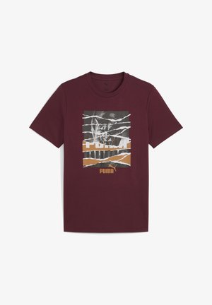 Bordo pamukasta majica s grafikom s složenim dizajnom u bijeloj, sivoj i bež boji. Uključuje Puma logo i fragmentirani tekst.
