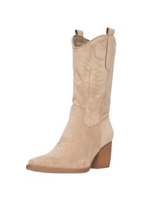 Bota de vaquero de ante beige con punta afilada, costuras decorativas y un tacón de madera apilada. Cuenta con dos lengüetas para facilitar el uso.