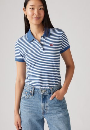 Prúhovaná polo košeľa v modrej a bielej farbe s gombíkovým golierom a logom Levi's. Skombinovaná s svetlomodrými džínsy s vysokým pásom.