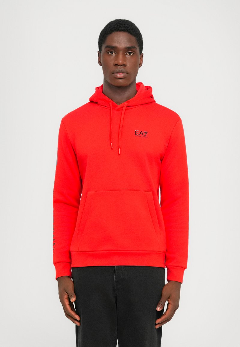 Sudadera roja con capucha y bolsillo frontal, con logo bordado. Presenta mangas largas y puños acanalados, fabricada en un material suave y texturizado.
