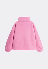Różowy polarowy sweter z podwyższonym kołnierzem, luźnymi rękawami i miękką, teksturowaną powierzchnią. Prosty, minimalistyczny design bez zdobień.