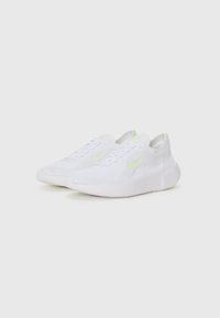 White athletic shoes with a textured knit upper, featuring light green accents and a cushioned sole. Laces and a sleek design enhance functionality.