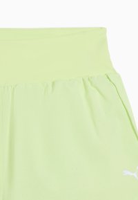 Jupe vert clair avec une large ceinture et un motif à petits pois subtils, comportant un logo Puma blanc près de l'ourlet.