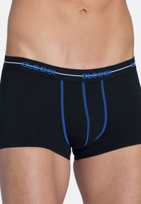 Schwarze Boxershorts mit blauer Naht und einem Markenbund, auf dem "Sloggi" in Blau und Weiß steht. Weicher, dehnbarer Stoff mit enganliegendem Schnitt.
