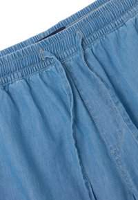 Pantaloni shorts in cotone azzurro chiaro con vita elastica, cordoncino e cuciture a contrasto. Presentano tasche laterali e una consistenza liscia.