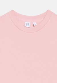 Gaiši rozā džemperis ar apaļu kakla izgriezumu, iekšpusē etiķete ar GAP KIDS un izmēra zīme, ražots Indonēzijā.