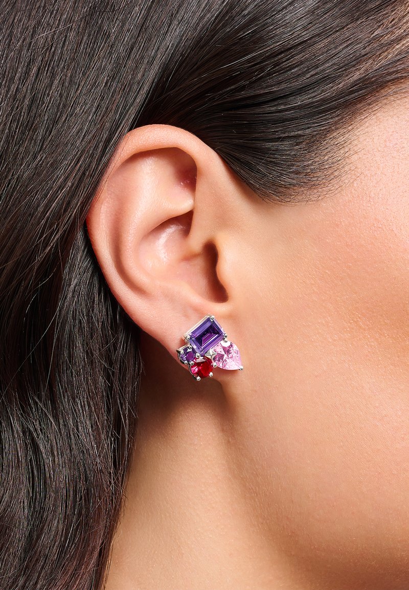 Mehrfarbige Ohrringe mit rechteckigen lila, rosa und roten Steinen aus Silbermetall, die nahe dem Ohrläppchen befestigt sind.