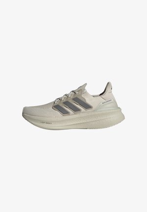 Zapatilla de correr Adidas Ultraboost de color beige claro con suela texturizada, tres franjas laterales grises y parte superior de punto con cordones.