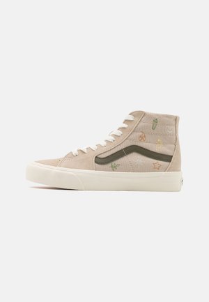 Beżowy trampki typu high-top z białymi sznurowadłami, zielonym paskiem po boku oraz małymi kolorowymi haftowanymi symbolami, w tym kaktusem, płomieniem, sercem, gwiazdą i słońcem.