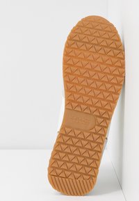 Semelle extérieure en caoutchouc avec motif de bande de roulement triangulaire et logo "U.S. Polo Assn." embossé sur la semelle.