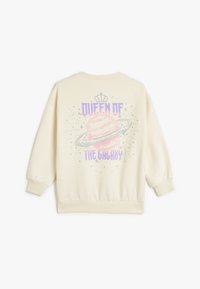 Kremowy sweatshirt z pastelowym grafiką planety i napisem "KRÓLOWA GALAKTYKI" oraz wzorem korony. Luźny krój i ściągacze przy mankietach.