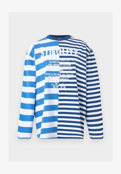 Πουκάμισο με μακριά μανίκια με εναλλασσόμενες φαρδιές και στενές μπλε και λευκές οριζόντιες ρίγες και λευκό κείμενο με φράσεις σχετικές με τη θάλασσα και γραφικά αστερία.