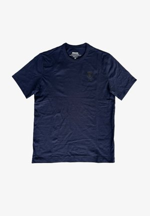 T-shirt a maniche corte di colore blu navy, realizzata in cotone. Presenta un colletto rotondo e un logo inciso in modo discreto sulla parte sinistra del petto. Texture liscia.