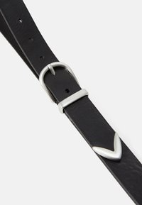 Cinturón de cuero negro con una hebilla de metal plateado y un acento en forma de V. Textura suave, varios orificios para ajuste, diseño minimalista.
